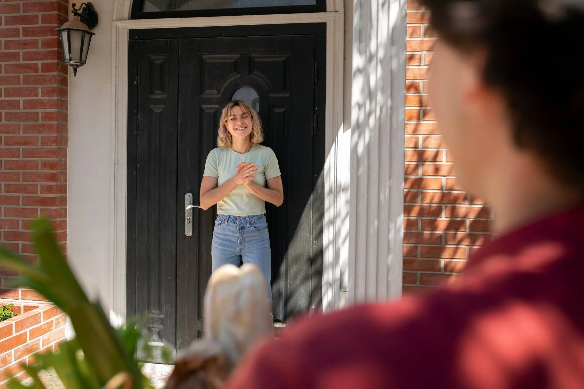 Mujer esperando en la puerta de su casa